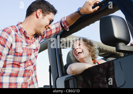 Smiling couple talking near jeep Stock Photo