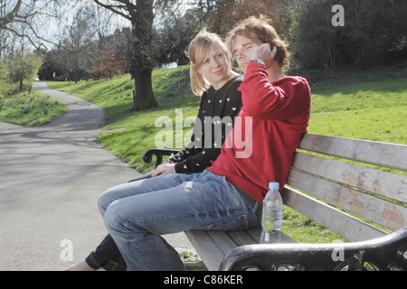 Couple talking on cell phone in park Stock Photo