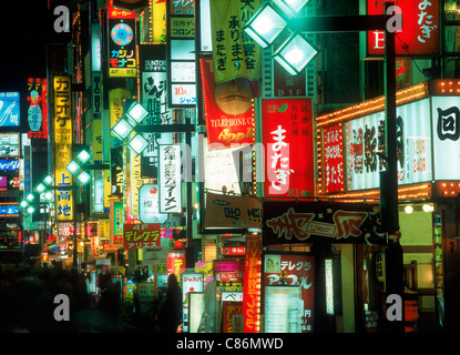 Neon lights and shops along walking street in Ginza district at night in Tokyo