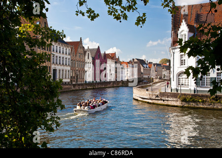 Tourist boat on the canal along the Spinolarei and Spiegelrei in Bruges,(Brugge), Belgium Stock Photo