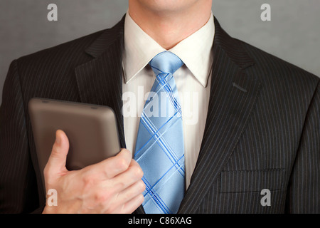 A close-up shot of a businessman holding a tablet computer. Stock Photo