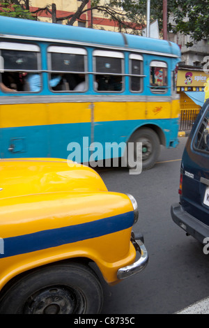 Yellow taxi and blue public transport bus in Kolkata (Calcutta), West Bengal, India. Stock Photo