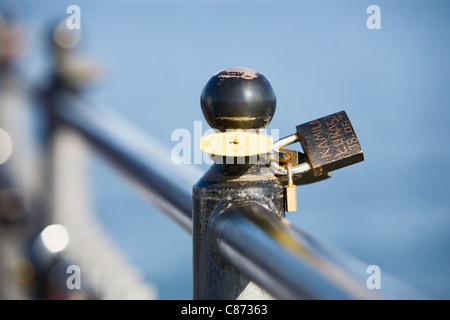 Metal padlocks hanging on fence, close-up Stock Photo