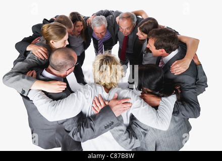 Business people forming huddle against white background Stock Photo