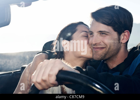 Spain, Majorca, Young woman kissing man in cabriolet car, close up Stock Photo