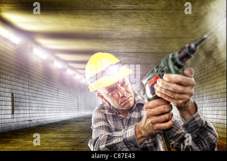 Construction worker with drilling machine in tunnel Stock Photo