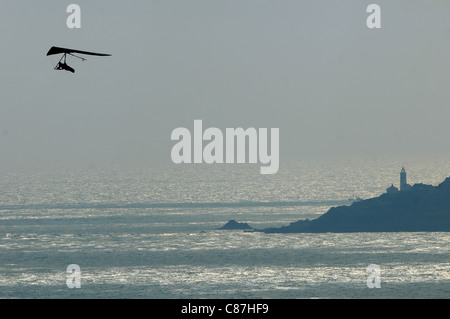 A hang glider uses the winds on the coast of South Devon overlooking Start Bay and Start Point. Stock Photo