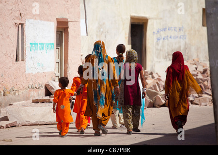 Indian women and girls dressed as wedding guests walking to the wedding in village of Rohet in Rajasthan, Northern India Stock Photo