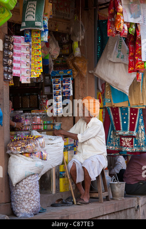 Indian shopkeeper in his food shop and general store in village of Rohet in Rajasthan, Northern India Stock Photo