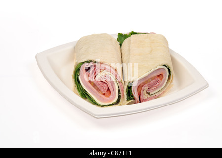 Italian deli meat wrap sandwich with cheese, lettuce and tomato cut in half on white plate on white background cutout. USA Stock Photo