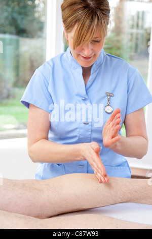 female massage therapist treating male patient Stock Photo