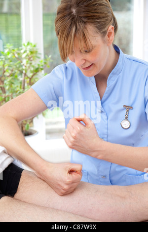 female massage therapist treating male patient with pounding / pummelling action Stock Photo