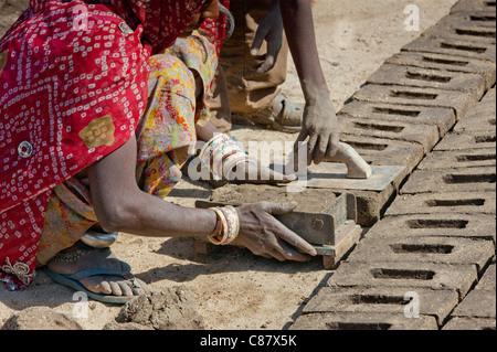 Indian family forming bricks made from mud clay at Khore Bricks Factory, Rajasthan, Northern India Stock Photo