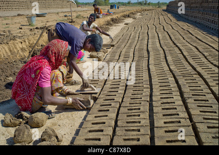 Indian family forming bricks made from mud clay at Khore Bricks Factory, Rajasthan, Northern India Stock Photo