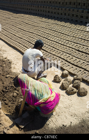 Indian family forming bricks made from mud clay at Khore Bricks Factory, Rajasthan, Northern India Stock Photo