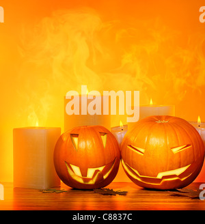 Halloween pumpkins holiday border, with candles and smoke, traditional jack-o-lantern over warm yellow light, decoration Stock Photo