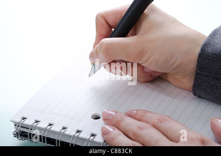 woman's hand with a pen on a notebook Stock Photo