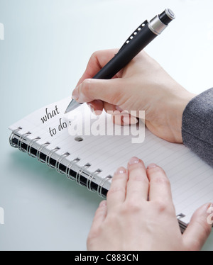woman's hand with a pen on a notebook Stock Photo