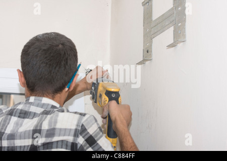 Technician air conditioning. Drill. Work on installing a new air conditioner Stock Photo