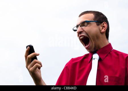 Shocked young Caucasian businessman looking at cellphone. Stock Photo