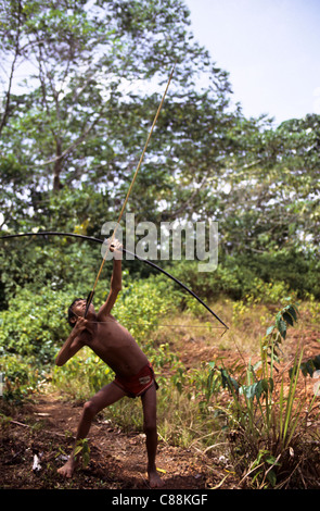 Roraima State, Brazil; Yanomami boy practising with bow and arrow in the rainforest. Stock Photo