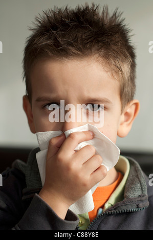 Child suffering from a cold. Cough with a tissue Stock Photo