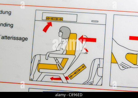 Closeup of an airline safety card showing how to prepare for take-off by putting luggage in the overhead locker or seat in front Stock Photo