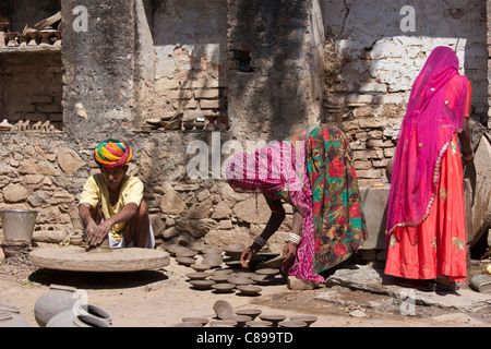 Potter in traditional Rajasthani turban works at home with his family making clay pots in Nimaj village, Rajasthan, India Stock Photo