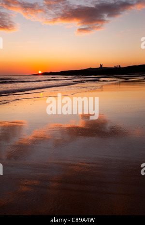 Sunrise over Dunstanburgh Castle, Embleton Bay, Northumberland, England, UK. Stock Photo