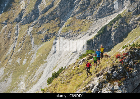 Austria, Kleinwalsertal, Group of people hiking on rocky mountain trail Stock Photo