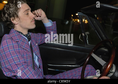 Germany, Hamburg, Man driving classic cabriolet car at night Stock Photo