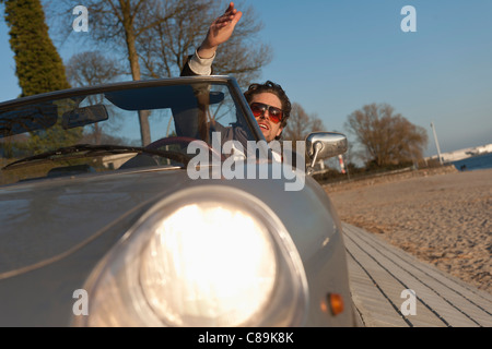 Germany, Hamburg, Man driving classic cabriolet car Stock Photo