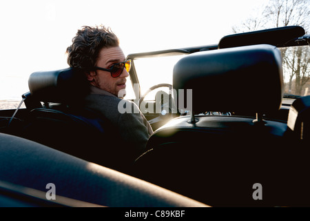 Germany, Hamburg, Man driving classic cabriolet car Stock Photo