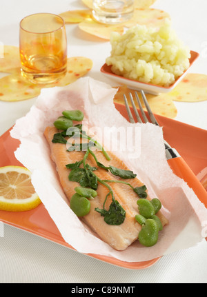 Trout fillet with watercress and broad beans cooked in greaseproof paper Stock Photo