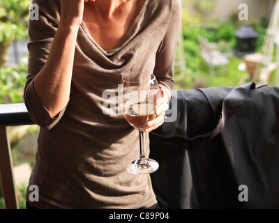 Woman drinking glass of wine at a garden party / BBQ in the garden Stock Photo