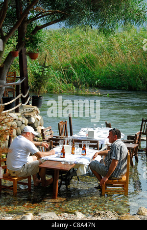AKYAKA, TURKEY. Two men drinking beer by / in the Azmak river, with the Gokova conservation area behind. 2011.