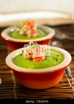 Cream of pea soup with shrimps Stock Photo