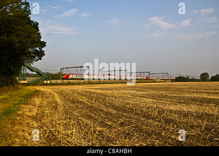 Virgin Trains Voyager trains passing harvested field near Comberford, Tamworth, Staffordshire. Stock Photo