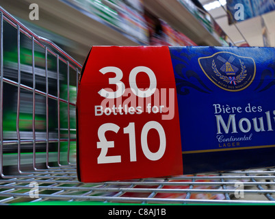 Carton of cheap bulk buy lager in supermarket trolley with speed blur effect Stock Photo