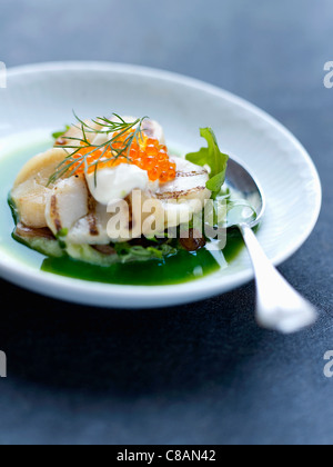 Green cabbage broth with scallops and salmon roe Stock Photo