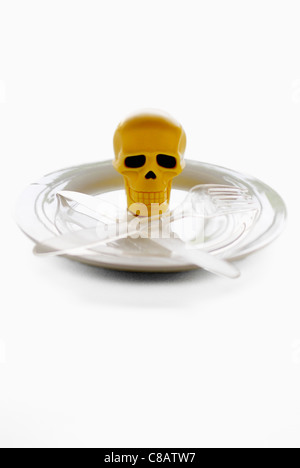 Skull on a plate with crossed knife and fork Stock Photo