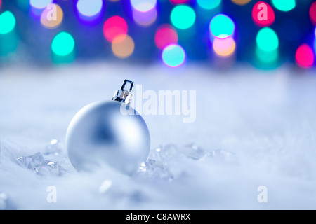 Christmas silver bauble in colorful blurred lights background Stock Photo