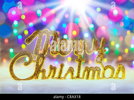 Merry christmas written in gold with colorful glowing lights Stock Photo