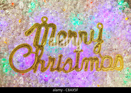 Merry christmas written in gold over colorful ice cubes Stock Photo