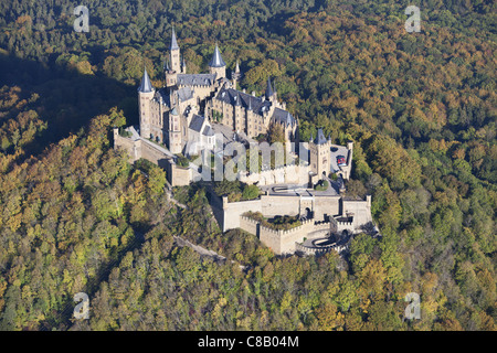 AERIAL VIEW. Castle on a forested hill with autumnal colors. Hohenzollern Castle, Hechingen, Baden-Wurttemberg, Germany. Stock Photo