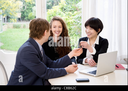 Attractive woman handing over keys to man Stock Photo