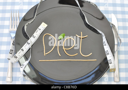 The word diet written with spaghetti on a plate with a measuring tape Stock Photo