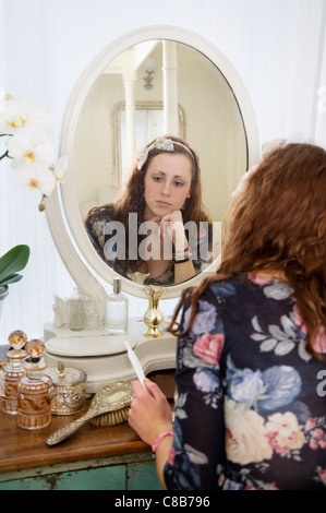 Pensive woman sitting at dressing table Stock Photo
