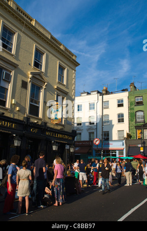 Corner of Elgin Crescent and Portobello Road streets on busy Saturday market day Notting Hill district London England UK Europe Stock Photo