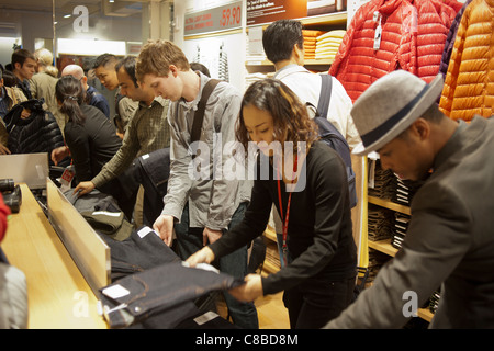 Customers shop at the grand opening of the Uniqlo Flagship store on Fifth Avenue in New York Stock Photo